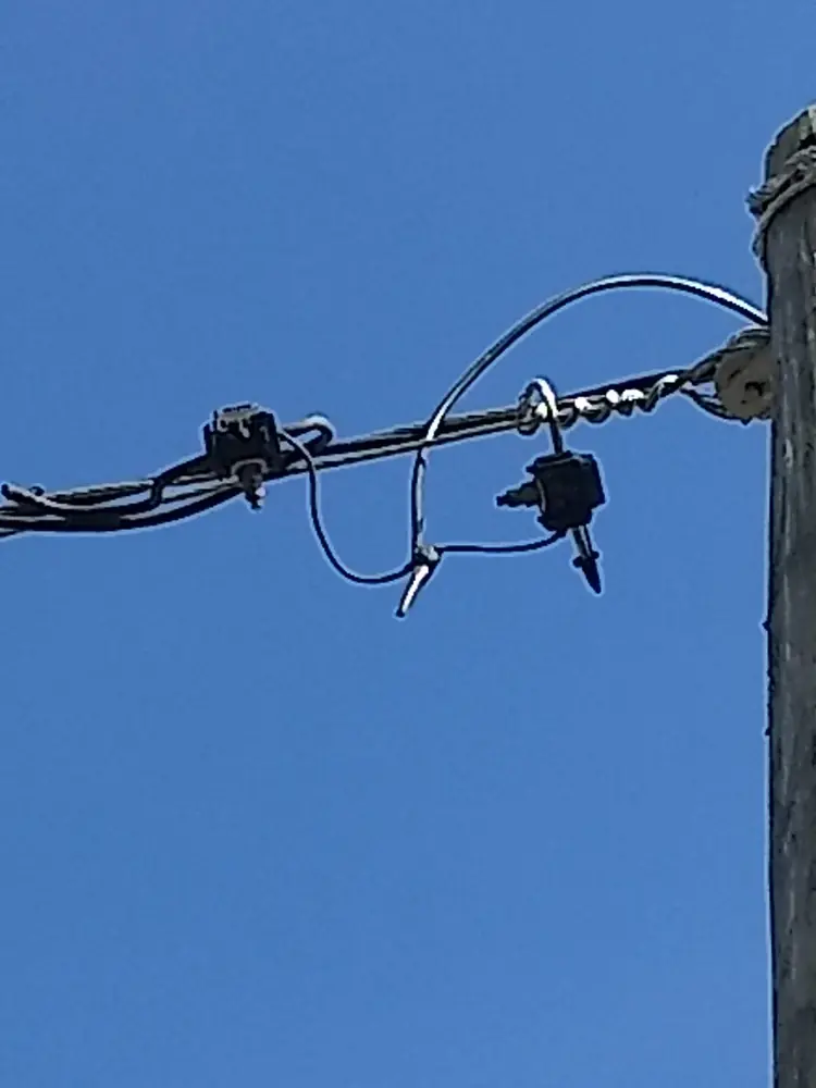 Acometida aérea conectada a la red en lo alto de un poste