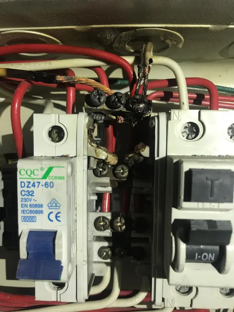 Automático con el borne superior ennegrecido por recalentamiento y cables con aislación dañada