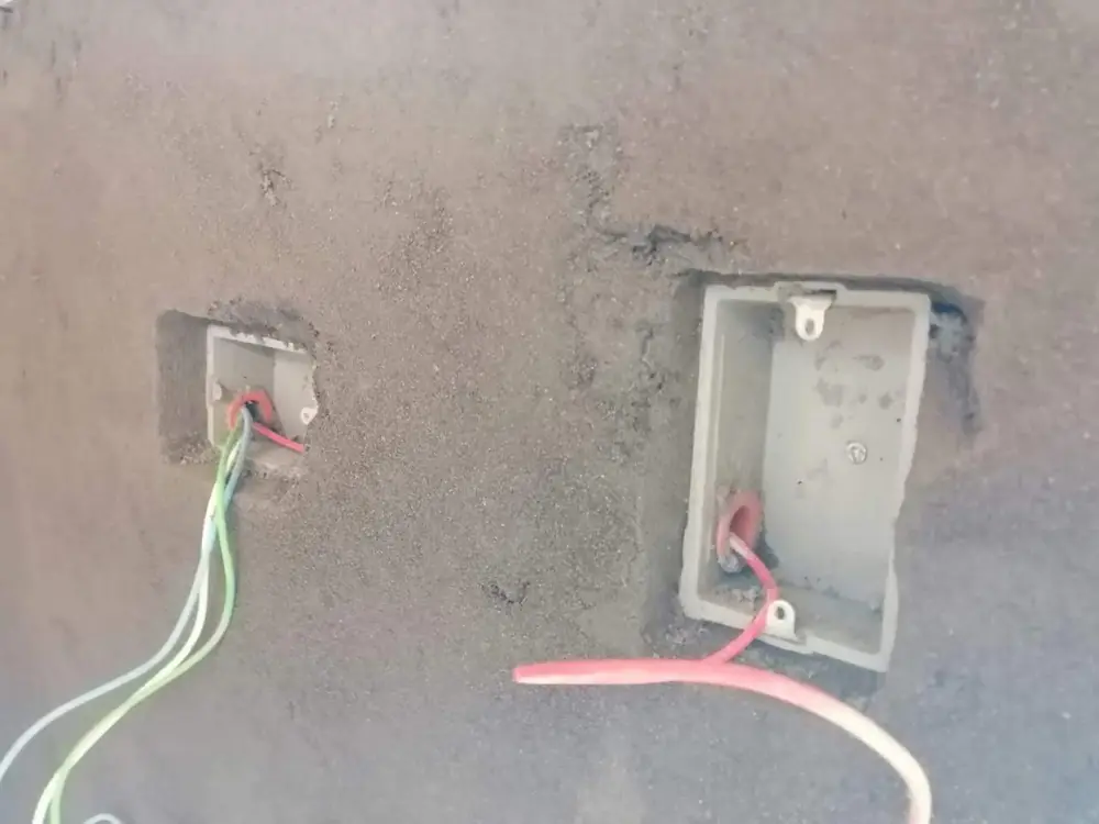 Cajas nuevas en el muro con los cables para puntos eléctricos