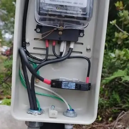 Caja de empalme abierta con el medidor y los cables de la acometida