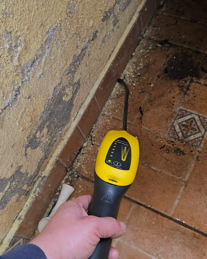 Detector de gas trazador buscando una fuga en un muro con humedad