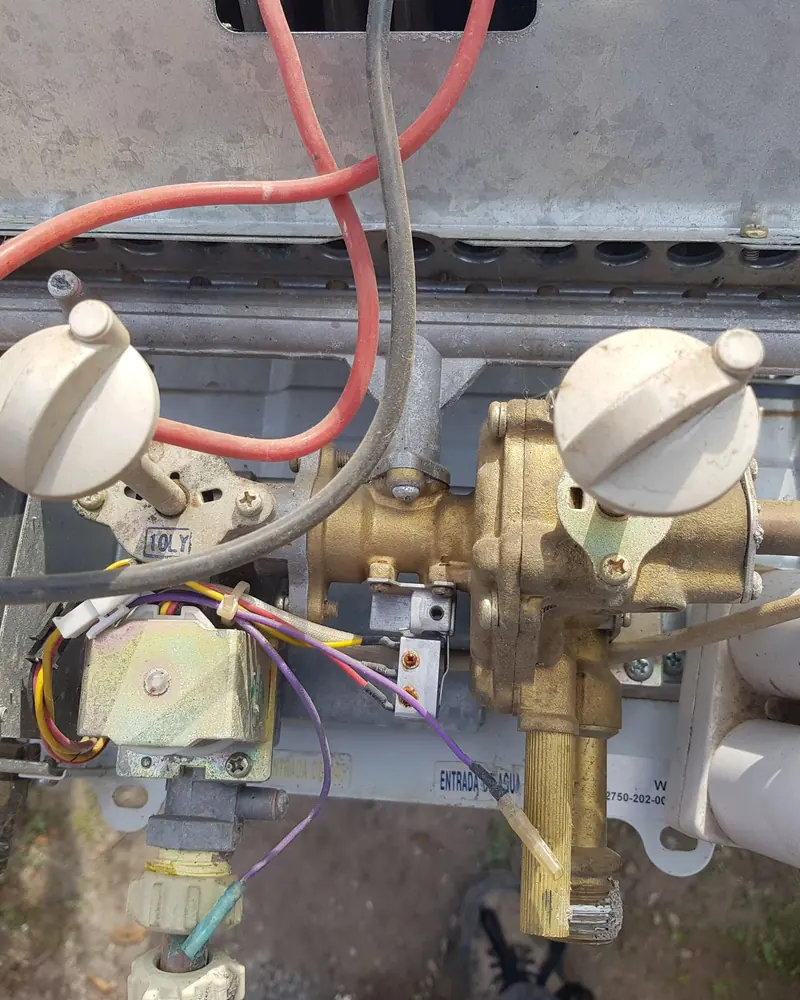 Válvula de bronce de un calefont con cables de colores y el microswitch