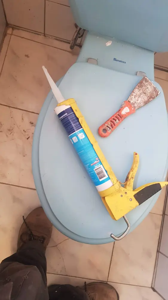 Asiento de WC con silicona y pistola para sellar